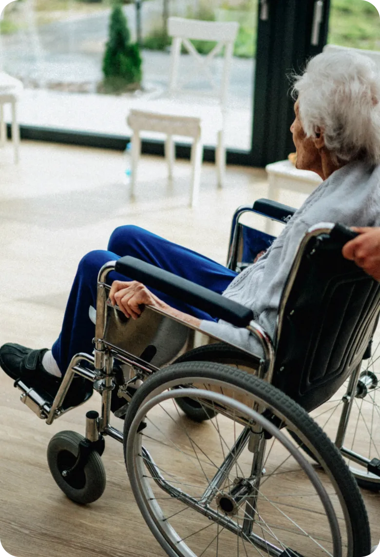 Caregiver assisting a senior woman in a wheelchair inside her home