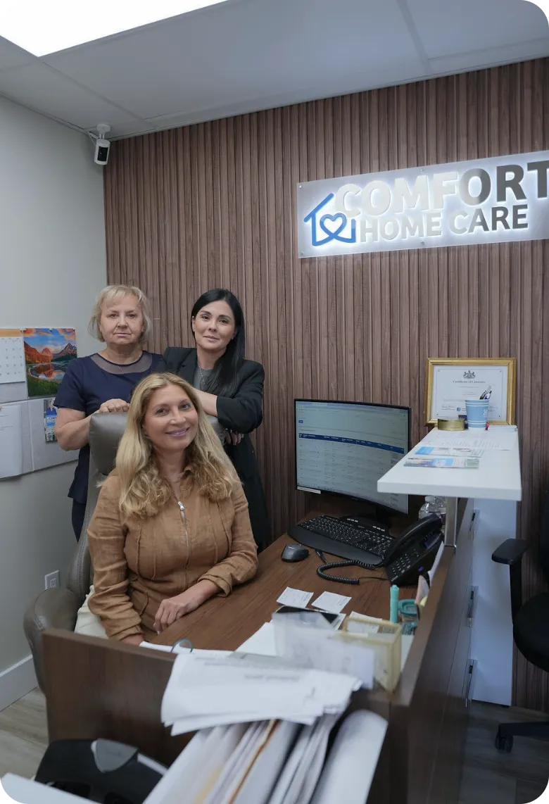 Comfort Home Care Team in the Company Office | Comfort Home Care Three Comfort Home Care staff members posing together inside the company office