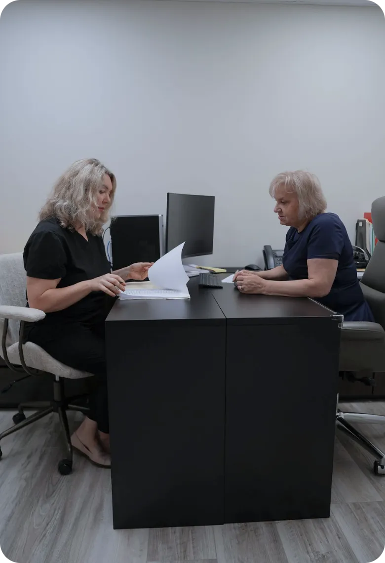 Comfort Home Care Staff Reviewing Documents in the Office | Comfort Home Care Two Comfort Home Care staff members reviewing documents together in the company office