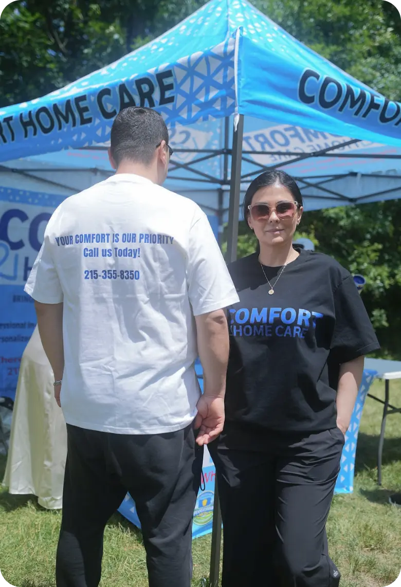 Comfort Home Care team members standing in front of a branded community outreach booth
